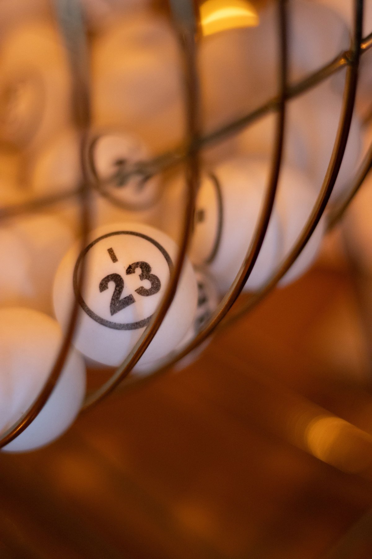 Close-up van de genummerde bingobal in de kooi, met nummer 23 in beeld